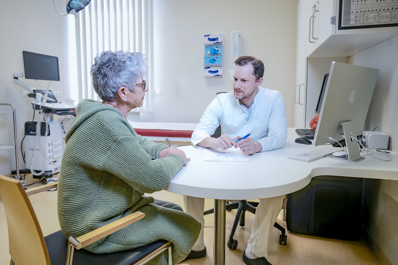 Ein Arzt der Klinik bespricht die Behandlung mit einer Patientin.