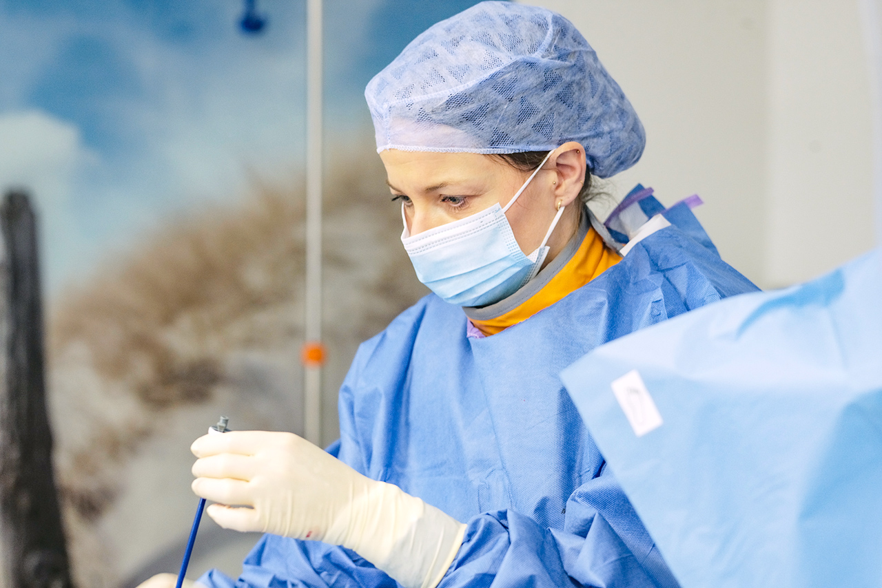 Eine Ärztin mit OP Kappe und Mundschutz.