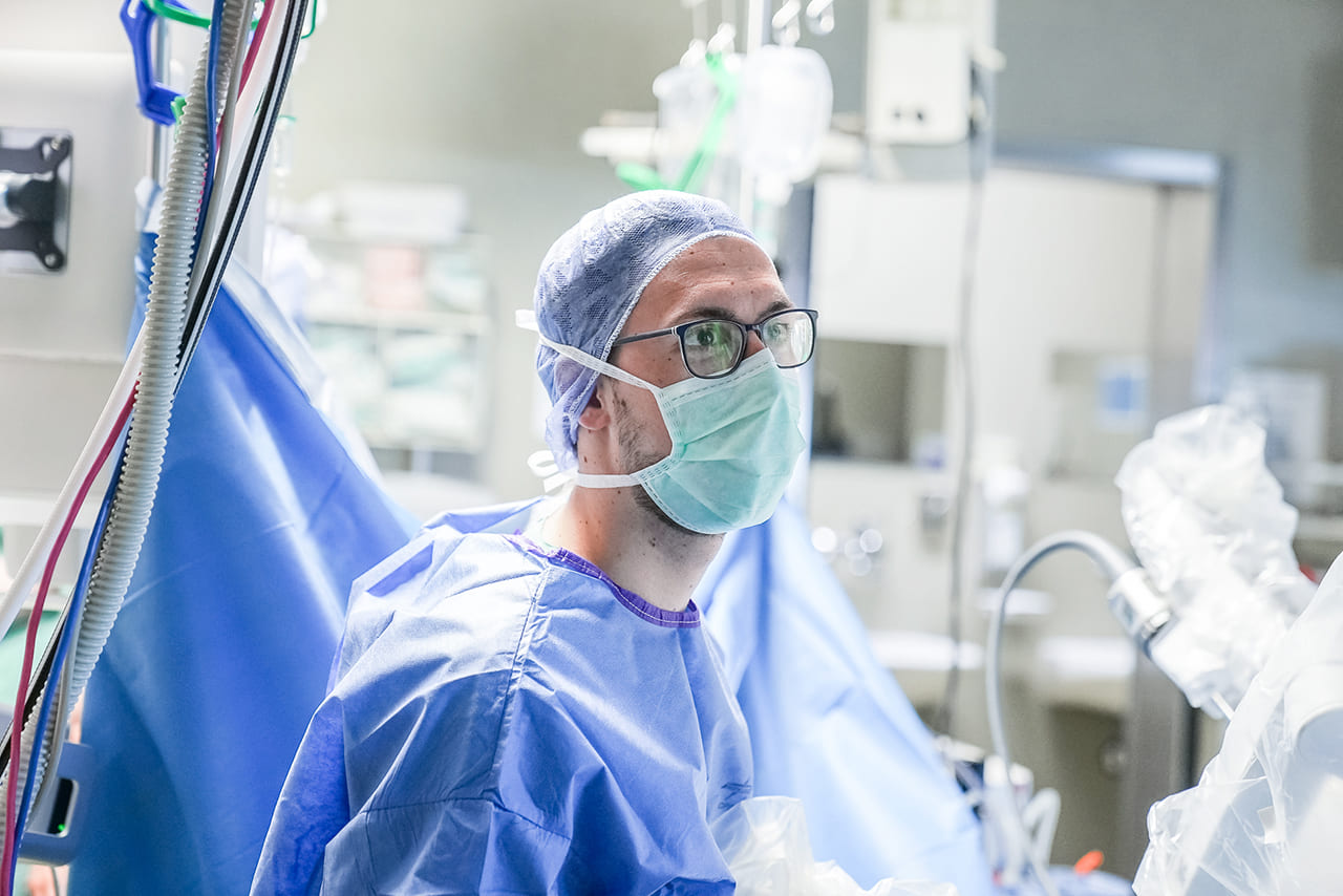 Ein Foto von einem Arzt mit Mundschutz und OP-Kleidung im OP.