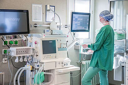 Eine OP-Schwester im OP blickt auf einen Monitor